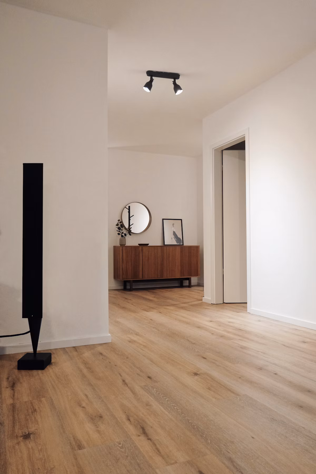 Flooring installer measuring hardwood planks in a bright living room